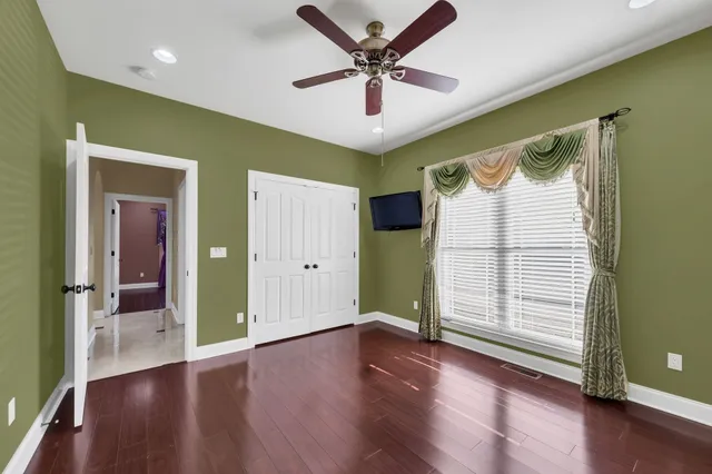 a view of a livingroom with wooden floor and a ceiling fan
