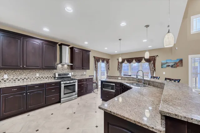 a large kitchen with granite countertop a stove and cabinets