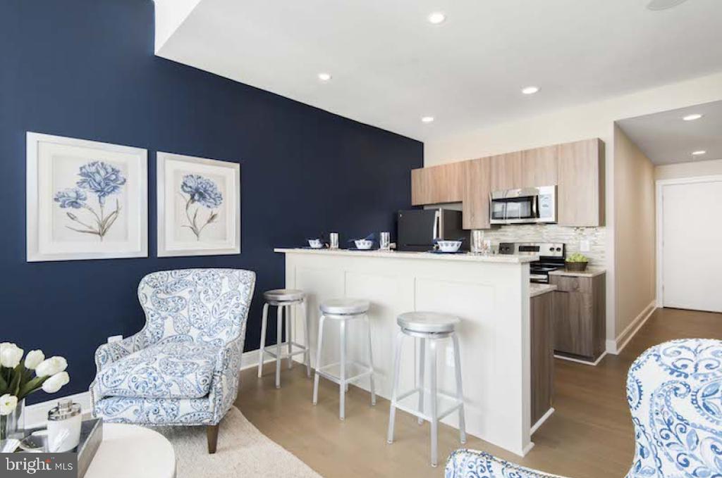 200 North 16th Street, Unit 2111 Philadelphia, PA 19102 - Photo 52 of 66 a kitchen with stainless steel appliances kitchen island granite countertop a refrigerator a stove a sink and a dining table with garden view