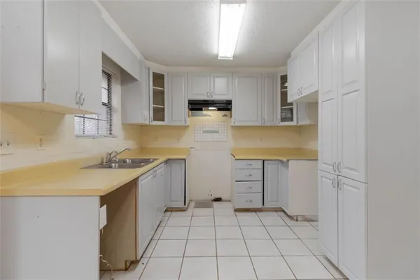 a kitchen with a sink a stove and cabinets