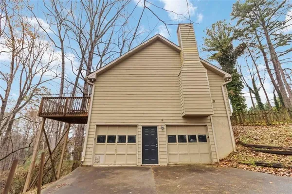 a view of a white house with a large tree