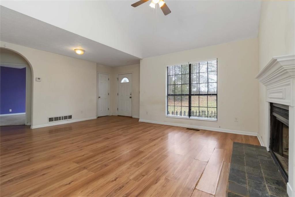 5552 Little Mill Road Buford, GA 30518 - Photo 9 of 30 a view of an empty room with wooden floor fireplace and a window