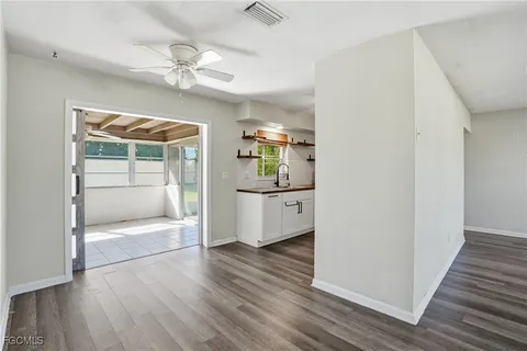 a view of a hallway view with wooden floor and cabinet