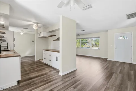 a view of a kitchen with wooden floor and a ceiling fan