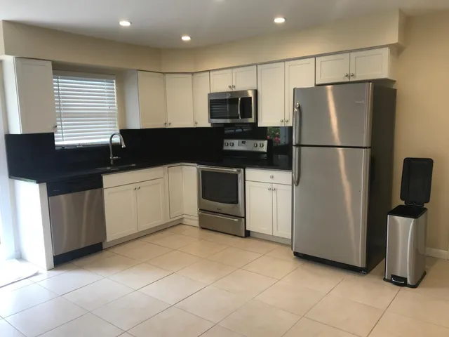 a kitchen with stainless steel appliances a refrigerator sink and microwave