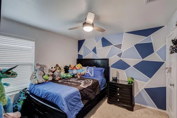 a bedroom with a bed and a ceiling fan