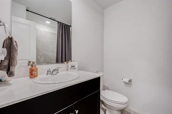 a bathroom with a sink vanity mirror and toilet