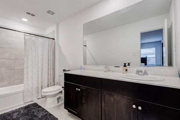 a bathroom with a double vanity sink toilet and shower