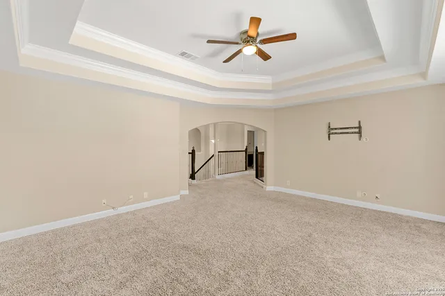 an empty room with ceiling fan and window