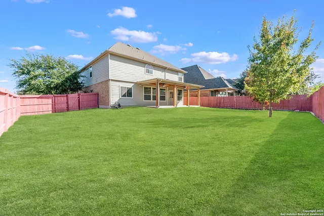 a front view of a house with a yard and trees