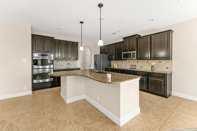 a kitchen with kitchen island a sink stainless steel appliances and cabinets