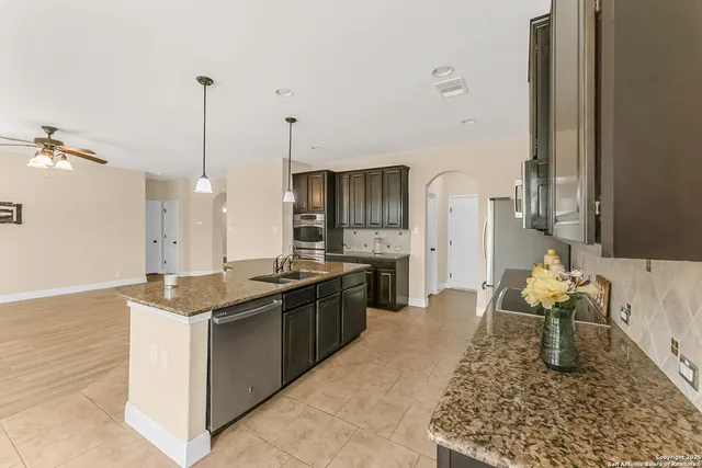 a large kitchen with granite countertop a sink and a stove