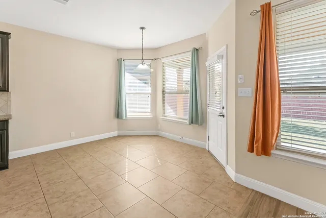an empty room with windows and chandelier