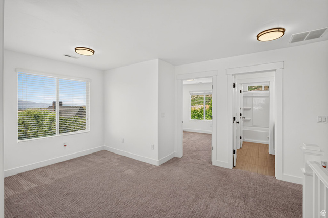 6536 West Muirfield Road Highland, UT 84003 - Photo 15 of 48 Upper-level landing area featuring neutral carpeting, white balusters, and a contemporary chandelier