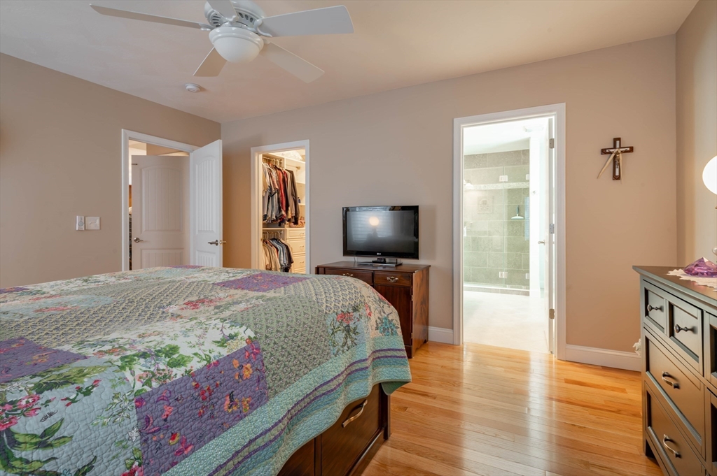 9 Pilgrim Circle Nashua, NH 03063 - Photo 20 of 39 a bedroom with a bed and a chandelier