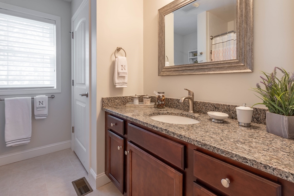 9 Pilgrim Circle Nashua, NH 03063 - Photo 24 of 39 a bathroom with a granite countertop sink and a mirror