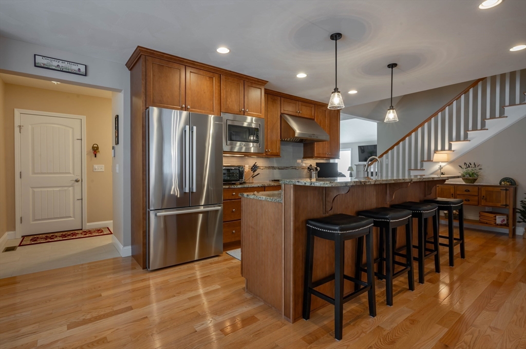 9 Pilgrim Circle Nashua, NH 03063 - Photo 10 of 39 a kitchen with kitchen island a dining table chairs stainless steel appliances and cabinets