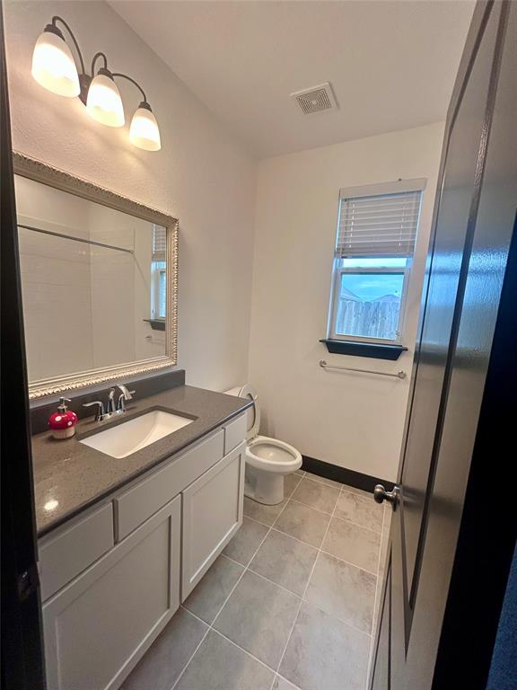324 Bronco Drive Pilot Point, TX 76258 - Photo 13 of 17 a bathroom with a toilet sink and mirror