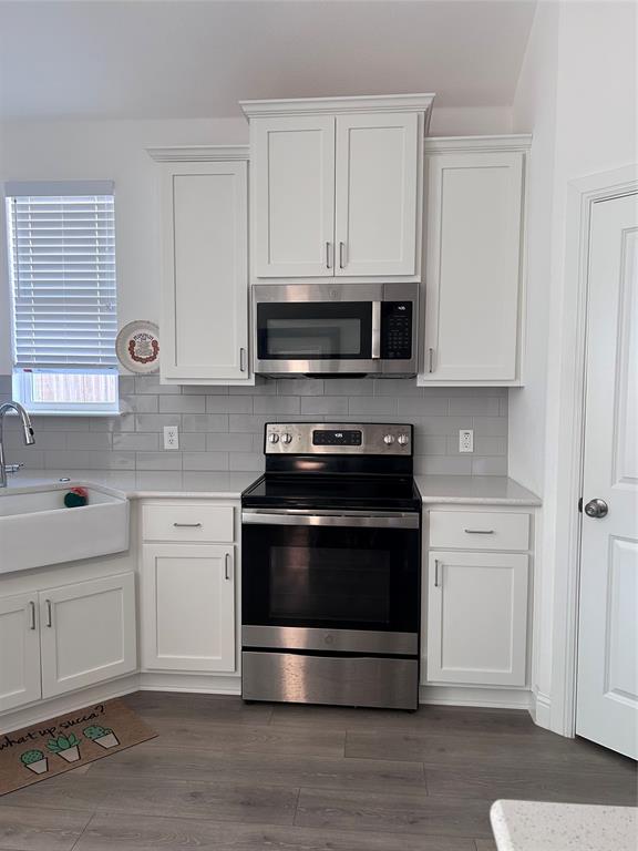 324 Bronco Drive Pilot Point, TX 76258 - Photo 6 of 17 a kitchen with stainless steel appliances a stove a microwave and cabinets