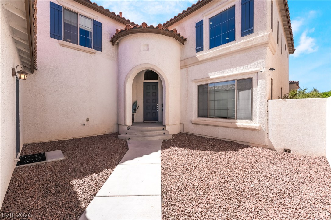 8358 Nelson Ridge Lane Las Vegas, NV 89178 - Photo 4 of 43 Architectural flair defines this home with its stucco finish, blue window shutters, and a distinctive arched entry.