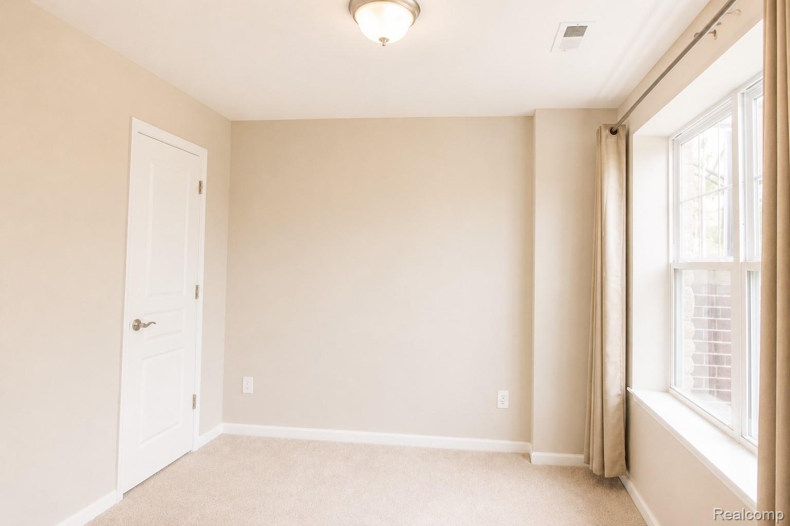2940 Glenbar Circle Rochester, MI 48307 - Photo 11 of 15 Neutral-toned room featuring light beige walls and complementing carpet flooring