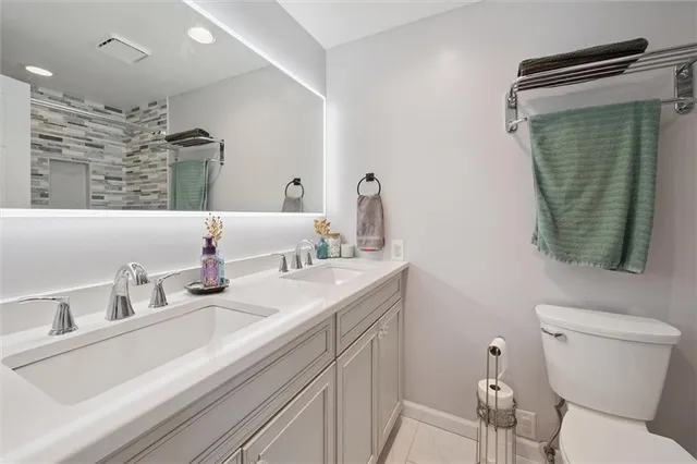 a bathroom with a toilet sink and mirror