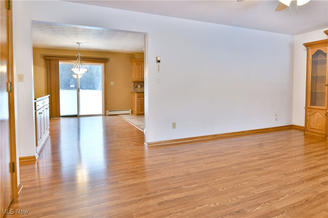 7155 Drake State Line Road Burghill, OH 44404 - Photo 5 of 50 Unfurnished room with light wood-style floors, ceiling fan, and baseboard heating