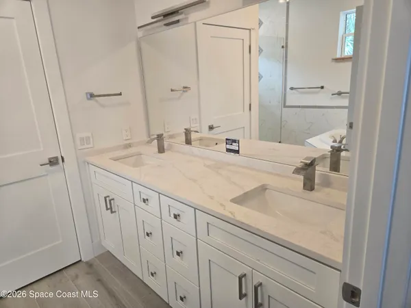 a bathroom with a shower sink and mirror