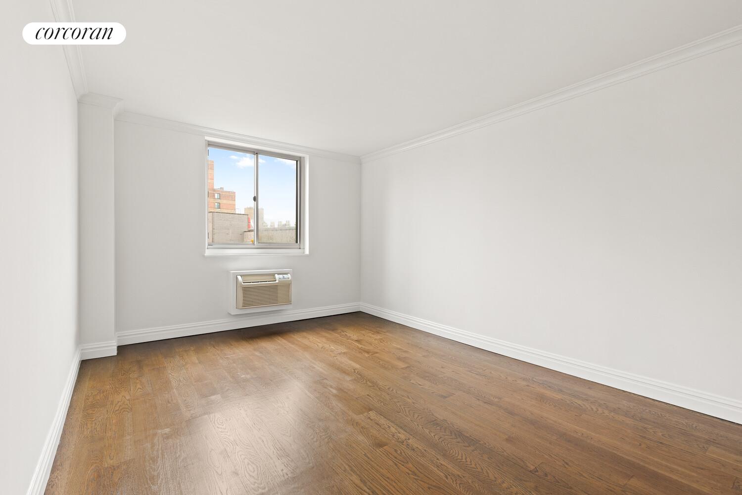 625 Main Street, Unit 643 Manhattan, NY 10044 - Photo 3 of 15 an empty room with wooden floor and windows