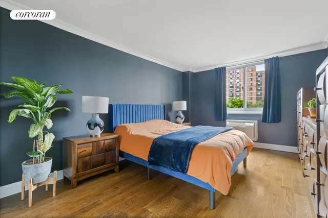 a bedroom with a bed table flowerpot and window