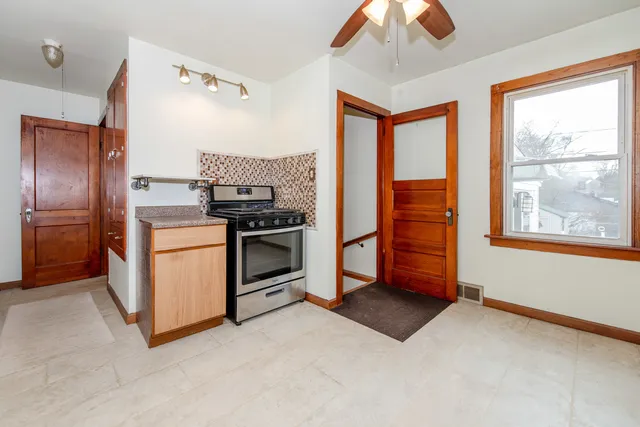 a kitchen with stainless steel appliances granite countertop a stove a refrigerator and a chandelier