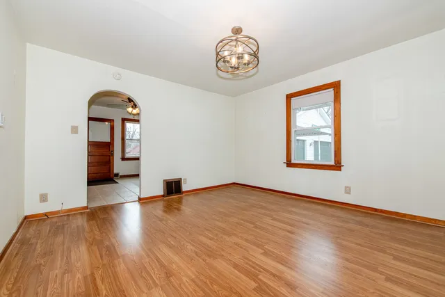 a view of empty room with wooden floor and window