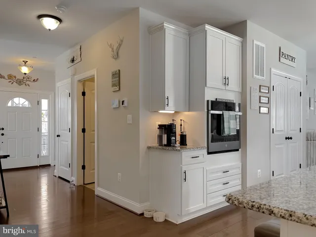 a dining room with stainless steel appliances kitchen island granite countertop a dining table chairs and a refrigerator