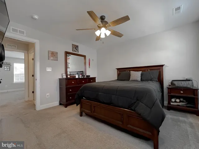 a spacious bedroom with a bed and a chandelier