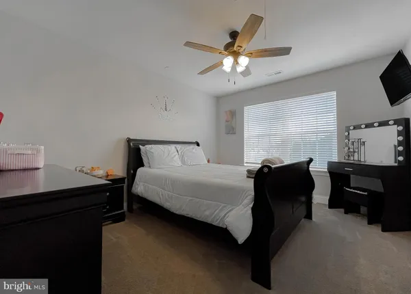 a spacious bedroom with a large bed and a chandelier