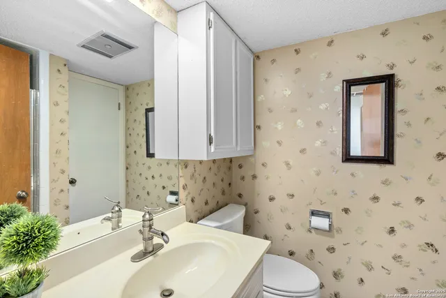 a bathroom with a granite countertop shower sink and mirror