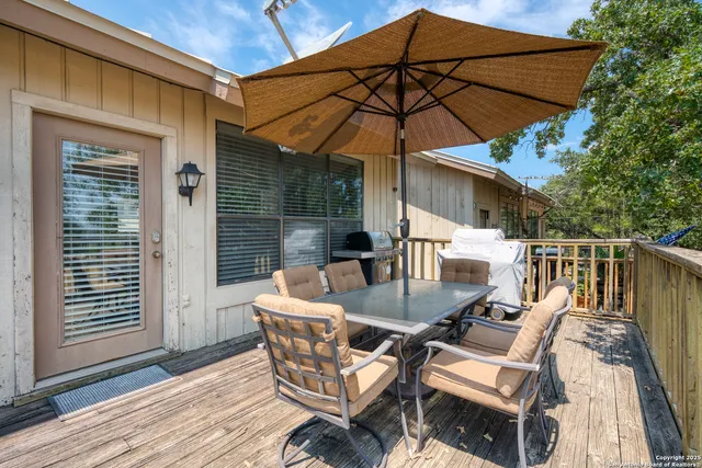 a view of a sign in a yard with potted plants and trees