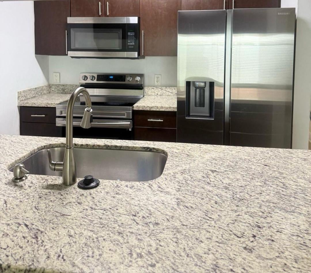 5820 Albert Road West Palm Beach, FL 33415 - Photo 2 of 14 a kitchen with granite countertop a sink and stainless steel appliances