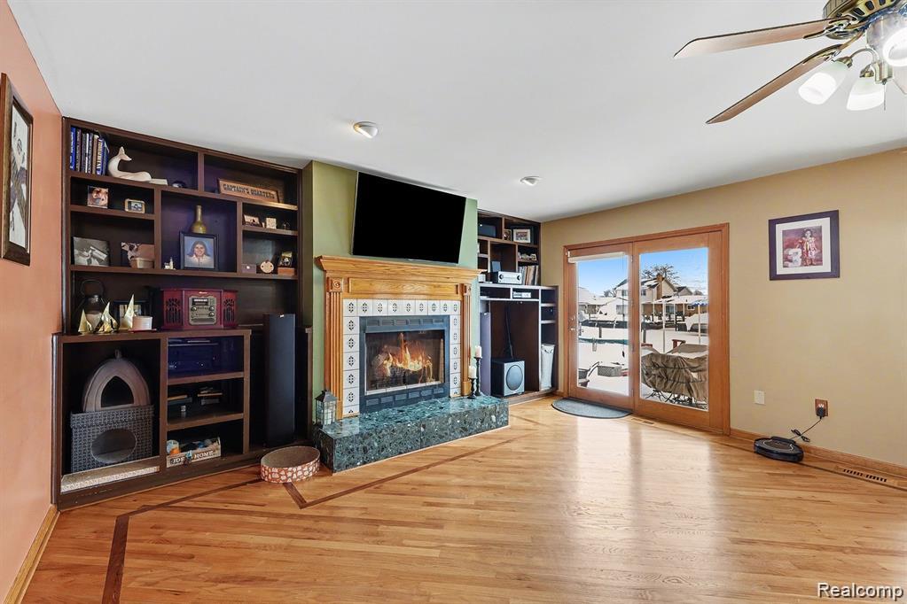 7277 Cardinal Road Algonac, MI 48001 - Photo 17 of 36 Unfurnished living room featuring a ceiling fan, light wood finished floors, and a premium fireplace