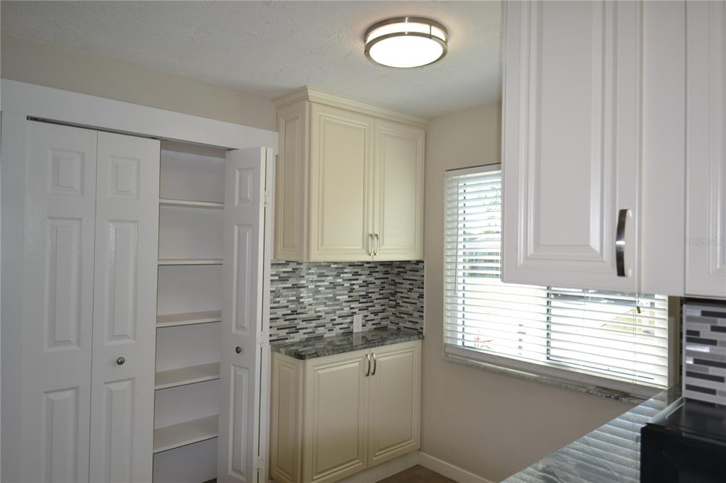 746 Barbara Street Palm Harbor, FL 34684 - Photo 2 of 54 a kitchen with white cabinets and window