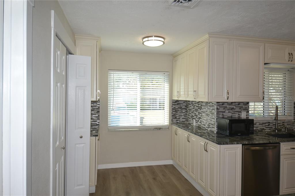 746 Barbara Street Palm Harbor, FL 34684 - Photo 28 of 54 a kitchen with stainless steel appliances kitchen island granite countertop a sink stove and cabinets