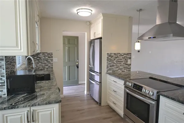 a kitchen with stainless steel appliances granite countertop a sink stove and refrigerator