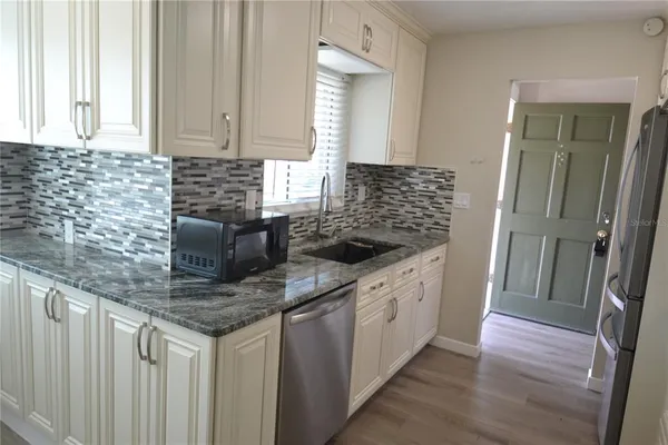 a bathroom with a granite countertop sink and a window