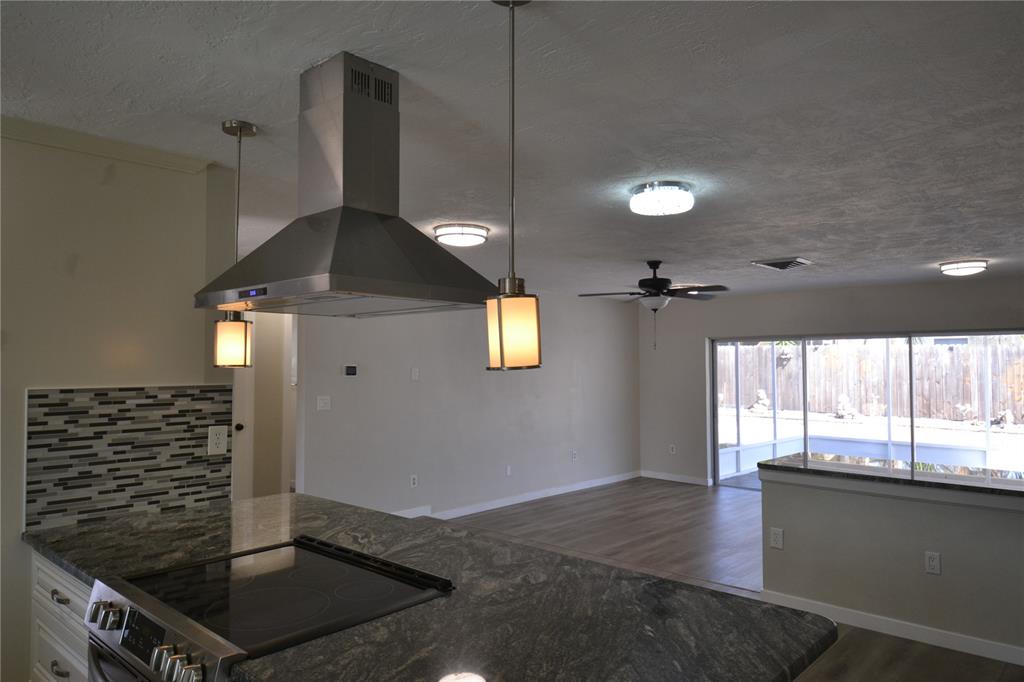 746 Barbara Street Palm Harbor, FL 34684 - Photo 5 of 54 a kitchen with kitchen island a counter space a stove and a window
