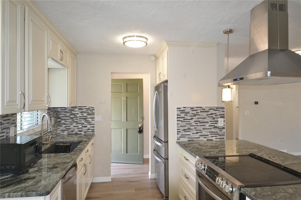 746 Barbara Street Palm Harbor, FL 34684 - Photo 7 of 54 a kitchen with granite countertop a sink stove and refrigerator
