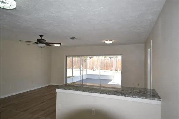 a view of a kitchen with wooden floor and a window