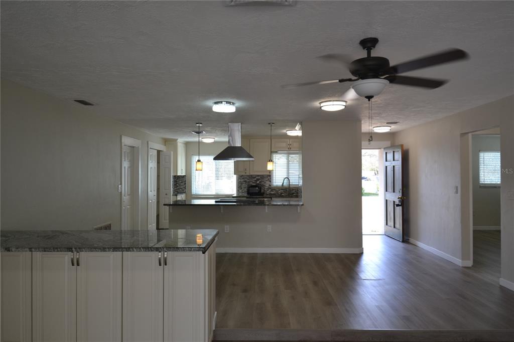 746 Barbara Street Palm Harbor, FL 34684 - Photo 9 of 54 a kitchen with stainless steel appliances granite countertop a refrigerator a sink dishwasher a stove and white countertops with wooden floor