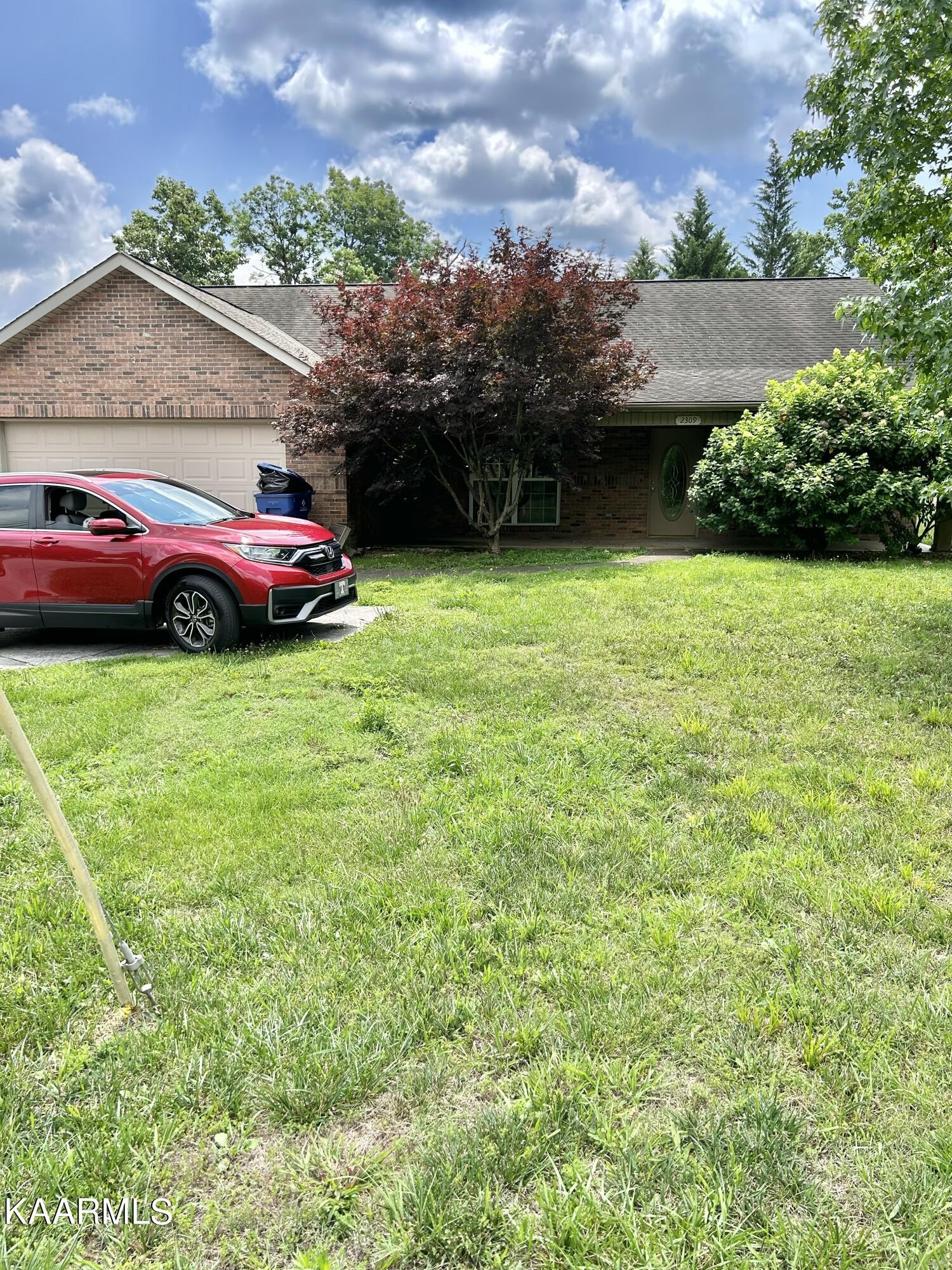a car parked in front of a house with a yard