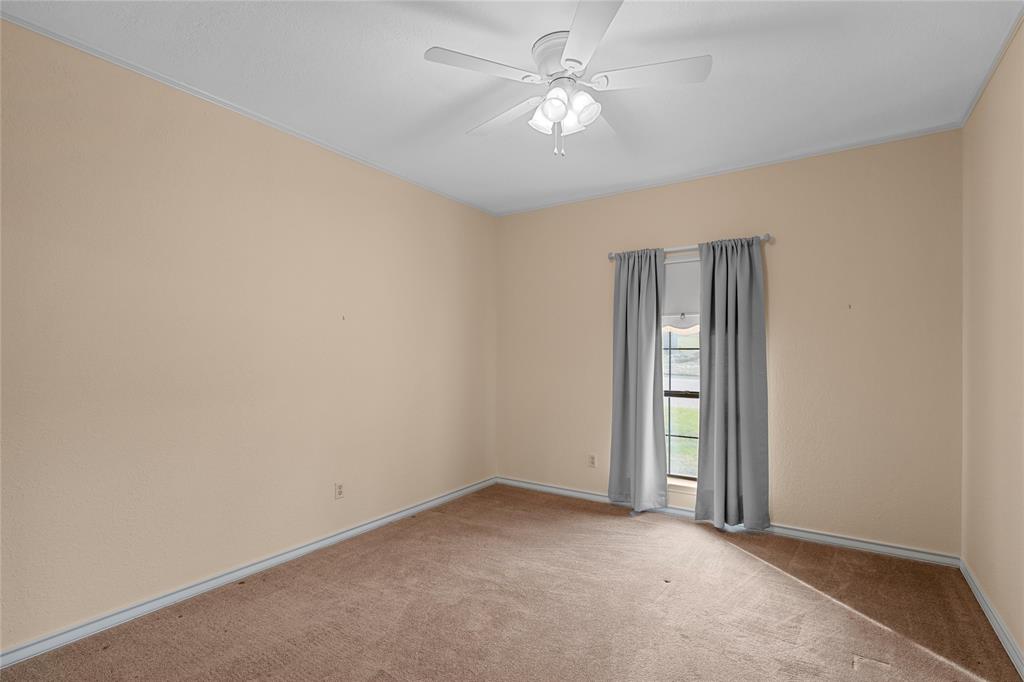2510 Oak Ridge Clifton, TX 76634 - Photo 16 of 26 an empty room with a ceiling fan and a window