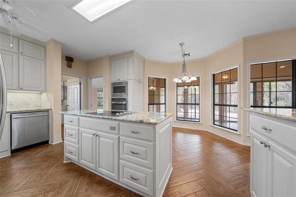 2510 Oak Ridge Clifton, TX 76634 - Photo 7 of 26 a kitchen with granite countertop a stove and white cabinets with wooden floor